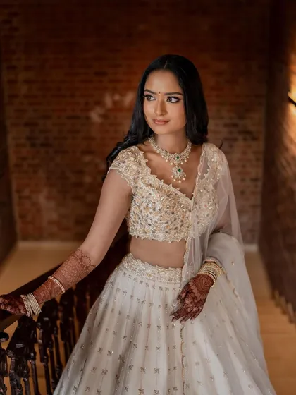 A close-up on her face and torso, showing the intricate details of her blouse and her flawless makeup.