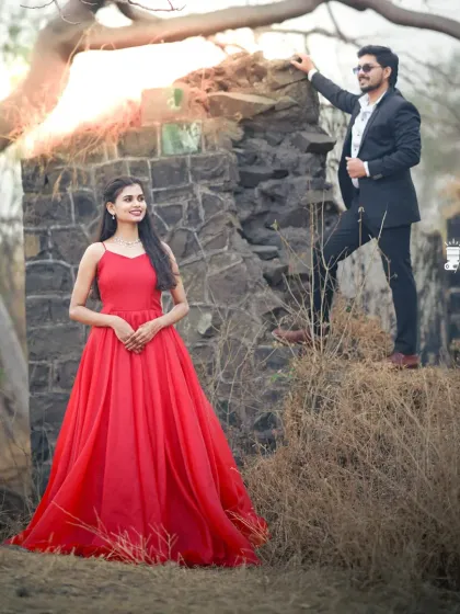 A romantic outdoor setting for a pre-wedding shoot. The bride-to-be looks radiant in a simple yet elegant red ball gown.