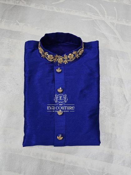 A close-up of a royal blue raw silk kurta. The collar is heavily embroidered with gold maggam work, adding a touch of luxury.