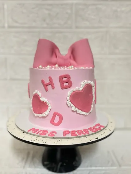 Another bowtiful cake from our collection. This pineapple cake is for "Miss Perfect," featuring a large pink bow and heart details.