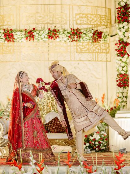 A playful Varmala moment on stage during a royal wedding in Pushkar, showing the fun and joy amidst the grand ceremonies.