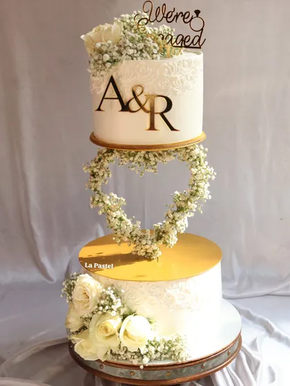 I love creating dramatic, multi-tiered cakes for big celebrations. This engagement cake features a floating heart made of delicate baby's breath, connecting two tiers for a truly magical effect. It's a perfect centerpiece for a modern romance.