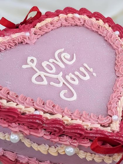 A close-up on the hand-piped "Love You!" script. We take care to make every detail perfect on our romantic vintage cakes.