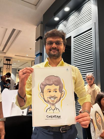 A smiling guest with his caricature, showing the clear and friendly likeness I aim for in my portraits.