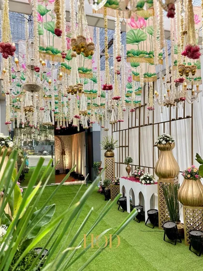 A view from the side of the green walkway, showing the intricate details of the hanging floral ceiling with lotus-printed drapes.