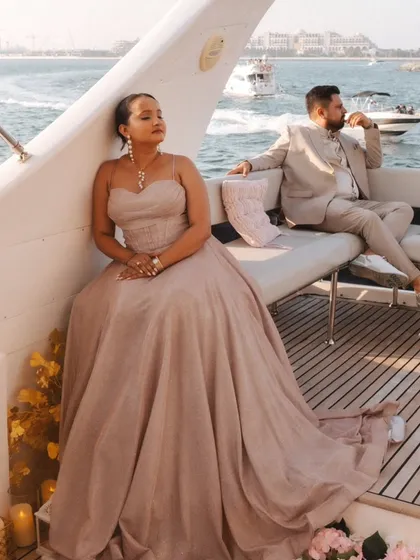 A glamorous portrait on the deck of a yacht. The bride's flowing gown and the stunning Dubai seascape create an image of pure elegance and luxury.