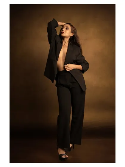 A powerful look for a modern brand. This studio shot uses a classic, moody backdrop and strong posing to create a sense of confidence and sophistication, perfect for a contemporary fashion lookbook.