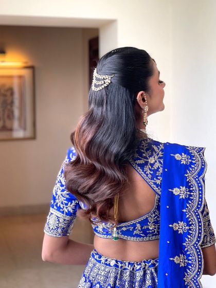 A beautiful half updo with soft waves, accented with a delicate kundan hair accessory. This is a great look for a Sangeet or engagement.