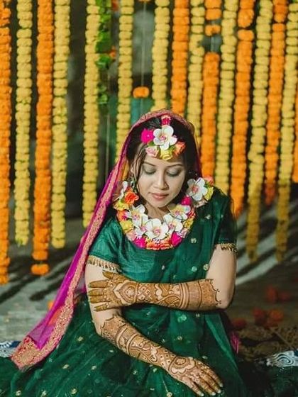A beautiful shot of a bride during her mehndi ceremony, adorned with floral jewelry that complements her henna.