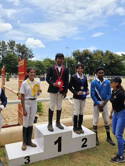 Our riders on the podium after a successful day at a show jumping competition. Every medal represents countless hours of hard work in the arena.