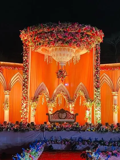 The royal palace stage seen during the day, showcasing the intricate details of the arches and the vibrant floral arrangements.