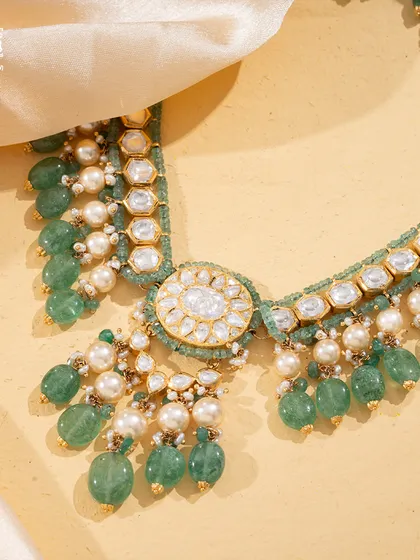 A close-up of the Tourmaline Trail, showing the interplay between the soft green tourmaline beads, lustrous pearls, and the central Polki diamond medallion.