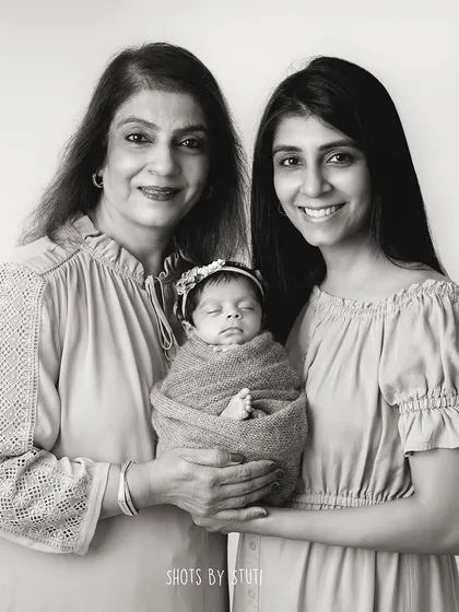 A beautiful composition with the grandmother and mother holding the newest family member.