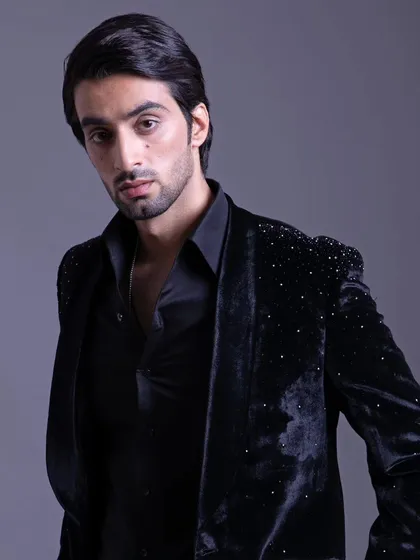 A black velvet jacket with subtle crystal embellishments on the shoulder. This piece offers a perfect blend of sophistication and modern flair.
