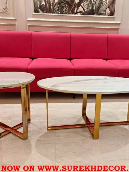 Our nesting tables offer versatility and high-end style. This set combines a classic oval coffee table with a matching circular side table, both featuring white marble tops and elegant cross-braced steel frames with a gold finish, perfect for sophisticated living rooms.