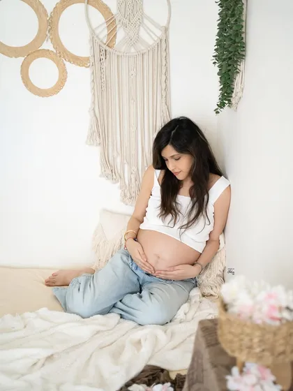 Your pregnancy, your style. This minimalist, boho-inspired setup with a casual white top and jeans shows how we can create beautiful, authentic portraits that feel just like you.