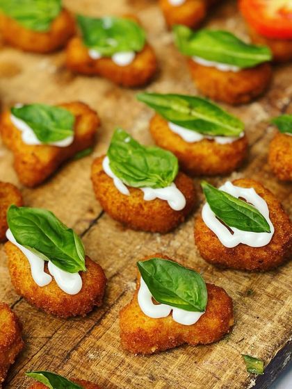 These are my Cheese Corn Shorts, a delightful bite-sized snack. The crispy exterior gives way to a warm, cheesy corn filling, topped with a fresh basil leaf for extra flavour.