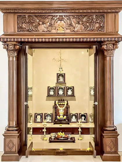 For this home, we designed and built a grand, traditional pooja mandir. The unit is framed by intricately carved wooden pillars and a decorative lintel, creating a truly magnificent and sacred space for prayer and reflection.