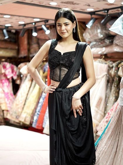 Step into the spotlight with this sleek black pre-draped saree and blouse, a chic fusion of tradition and modernity.