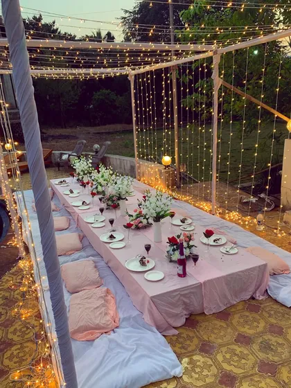 An intimate sit-down dinner arrangement for a bridal shower. I used low seating with cushions and a beautifully decorated long table under a canopy of fairy lights.