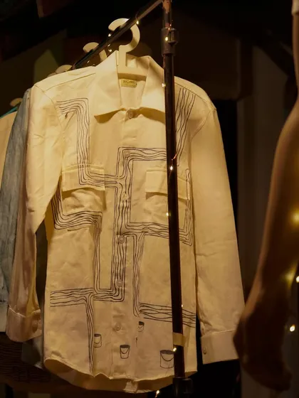 A custom hand-painted shirt on display. The intricate line work, done with natural dye paste, shows how we can create modern, artistic designs using ancient, eco-friendly techniques.