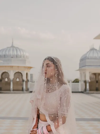 A stunning portrait of the bride under her veil, with the palace domes in the background. Every detail is planned to create an ethereal and regal bridal look.