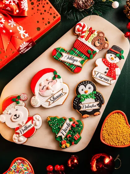 A platter of personalized Christmas cookies, each intricately decorated and featuring a different name. These custom vanilla butter cookies are a wonderful way to make guests feel special at a holiday party.