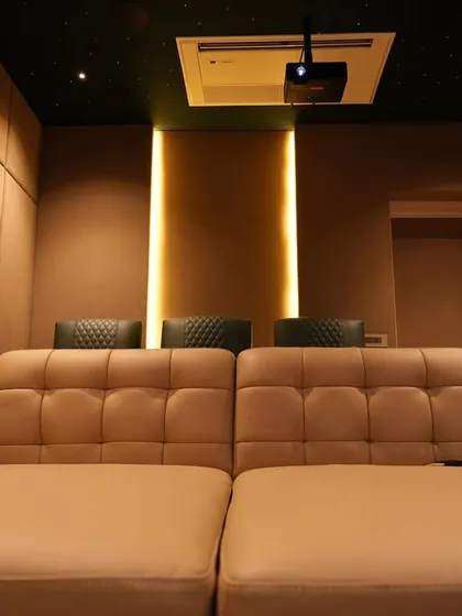 The stunning 'after' of the Nellore project. The same room is now a cozy and luxurious home theater, complete with a starlight ceiling, custom ambient lighting, and comfortable, multi-level seating.