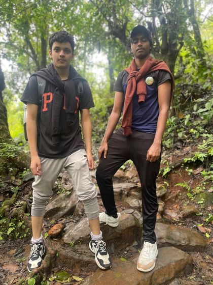 Two trekkers taking a short break on the rocky path inside the forest section of the Netravati trail. Proper trekking gear is always a good idea.