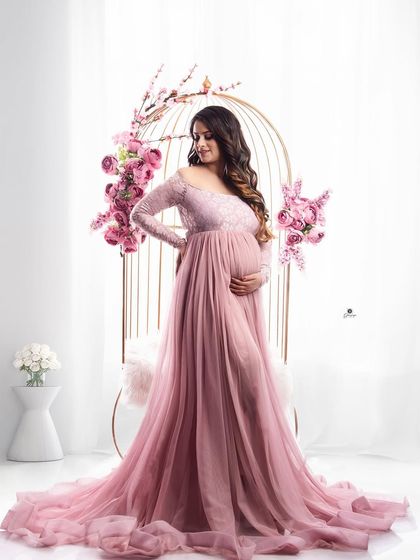 A lovely portrait featuring the golden birdcage prop decorated with pink flowers. The client's matching pink lace gown creates a romantic and cohesive fairytale scene.