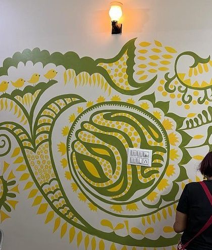 Caught in the act of painting the 'Harmony' mural. You can see how I work across the canvas, building up the design section by section. The four little birds perched on the leaves are my favorite part.