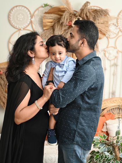 Kisses for the birthday boy! This adorable family portrait captures a moment of pure love and affection from both parents.