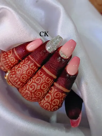 Another view of the pink ombré bridal nails, showing how they elegantly extend the nail bed and complement the henna-stained fingers.