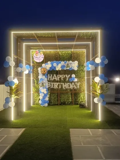 A simple balloon decoration for a birthday party in an outdoor setting with a green wall.