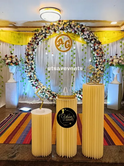 An elegant engagement stage featuring a large floral ring. This romantic design uses a full circle of fresh flowers with a custom couple's monogram, creating a beautiful focal point for the ceremony.