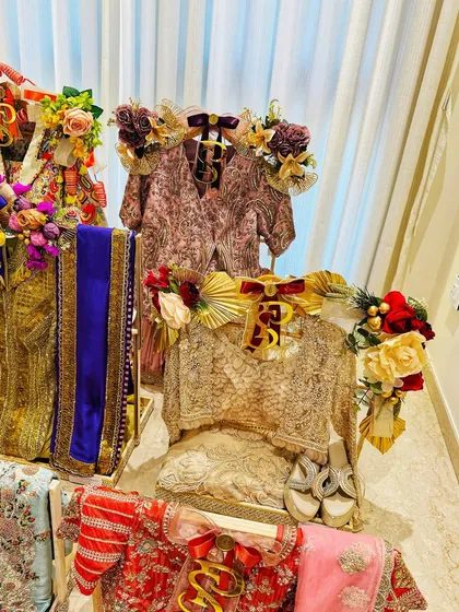 A closer look at the styled outfits. I adorn each piece with regal ribbons, floral accents, and personalized initials to make the presentation as special as the attire itself.