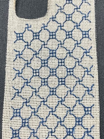 A close-up of a finished phone insert with a complex Kasuti-inspired pattern in a single color. The precision of the counted thread work is clearly visible.