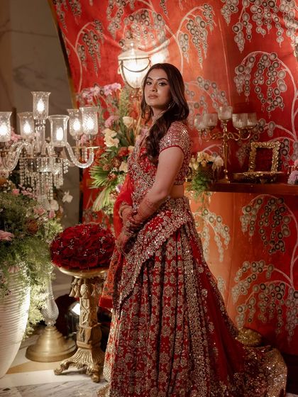 The beautiful bride posing against the custom-printed fabric wall at the entrance of her reception.