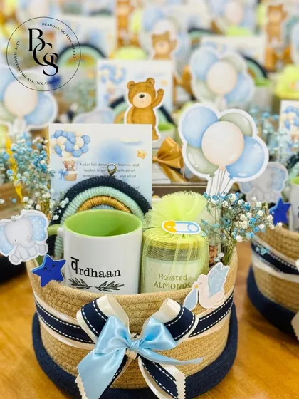 Announcing a new arrival is pure joy. This baby boy announcement hamper is designed to be as adorable as the little one, featuring a personalized mug, a jar of roasted almonds, and cute themed decorations like a rainbow and teddy bear cutouts, all arranged in a charming rope basket.