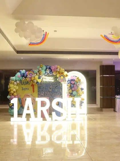 A wide view of the party hall, showing how we used floating cloud and rainbow balloons to decorate the ceiling and carry the theme throughout the space.