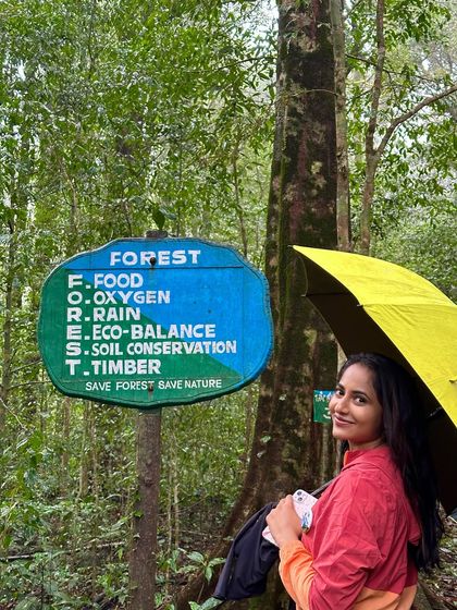 A trekker poses next to a forest department sign that beautifully explains the importance of the forest ecosystem. We believe in and promote responsible trekking.
