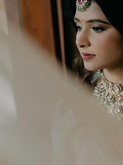 A soft and dreamy close-up of Ipsa. The sheer fabric in the foreground adds a layer of depth and softness, creating an ethereal and romantic bridal portrait.