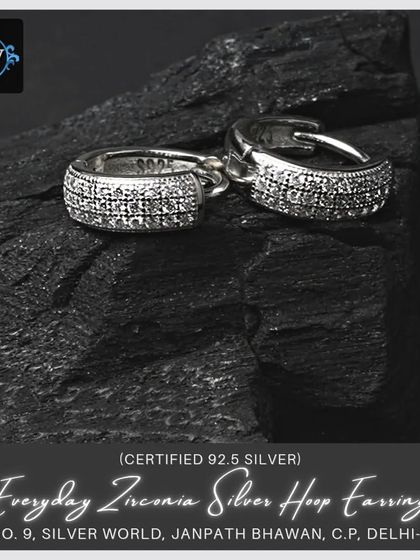 Our everyday zirconia silver hoop earrings are perfect for adding a bit of sparkle. This image shows them on a dark, textured background, highlighting their shine.