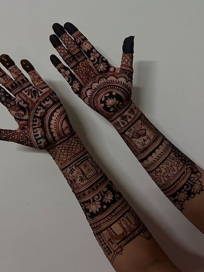 This angle showcases the full length of the personalized mehendi, with elephants, jharokhas, and other custom elements creating a narrative on the arms.