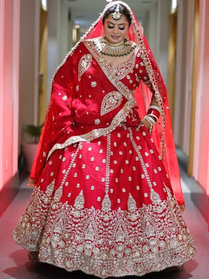 The elegance of a traditional red bridal lehenga is unmatched. Here, the makeup is designed to harmonise with the rich embroidery and colours.