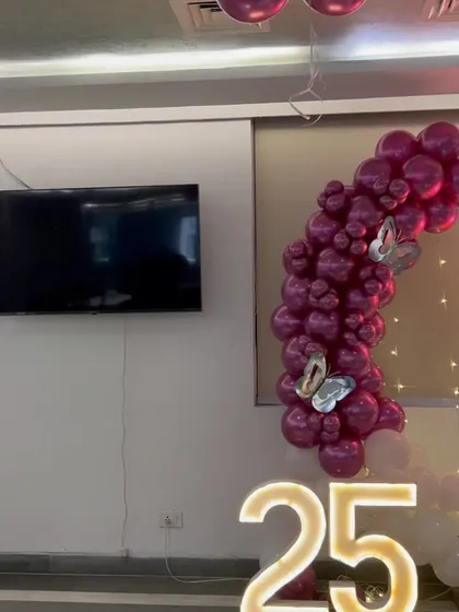 A partial view of the 25th anniversary setup, showing the marquee numbers and a portion of the balloon arch.