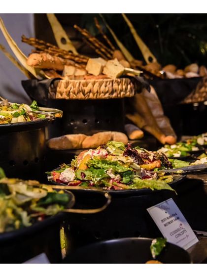 A fresh salad bar setup as part of a larger buffet. We always include a variety of healthy and refreshing salads with premium ingredients and house made dressings.