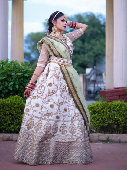 A full view of the white and gold embroidered lehenga. This rental outfit is perfect for brides looking for a non-traditional color that is still incredibly elegant and bridal.