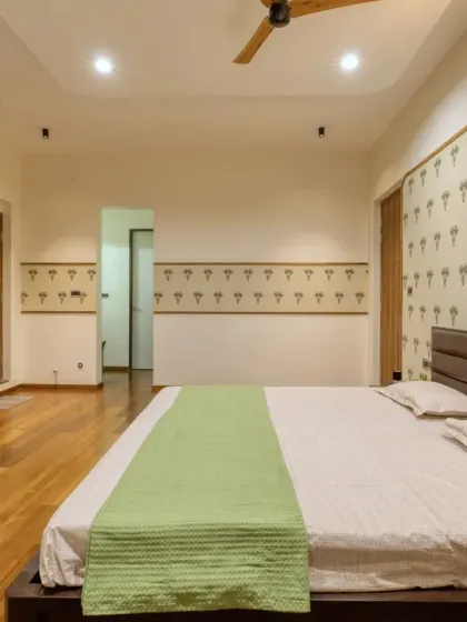 A tropical-inspired wallpaper and custom floral knobs on the wardrobes add a touch of quiet elegance and charm to the parents' room.