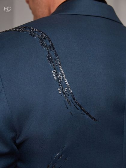 A detail shot of the abstract, brushstroke-like embroidery on the back of the jacket. This is where artistry and tailoring meet.